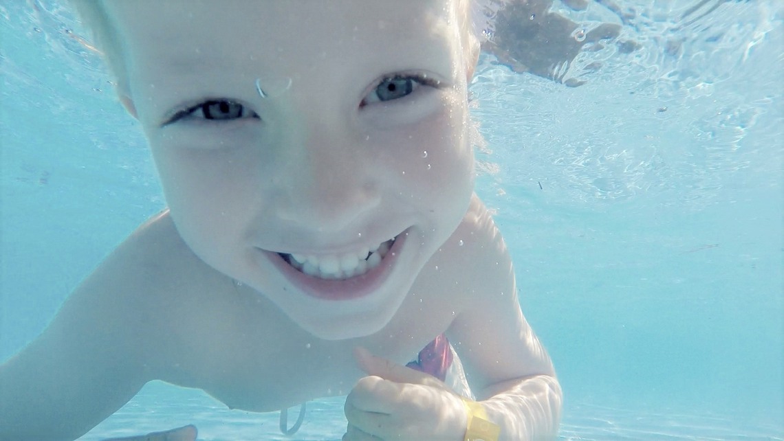 Ett barn badar i en pool.