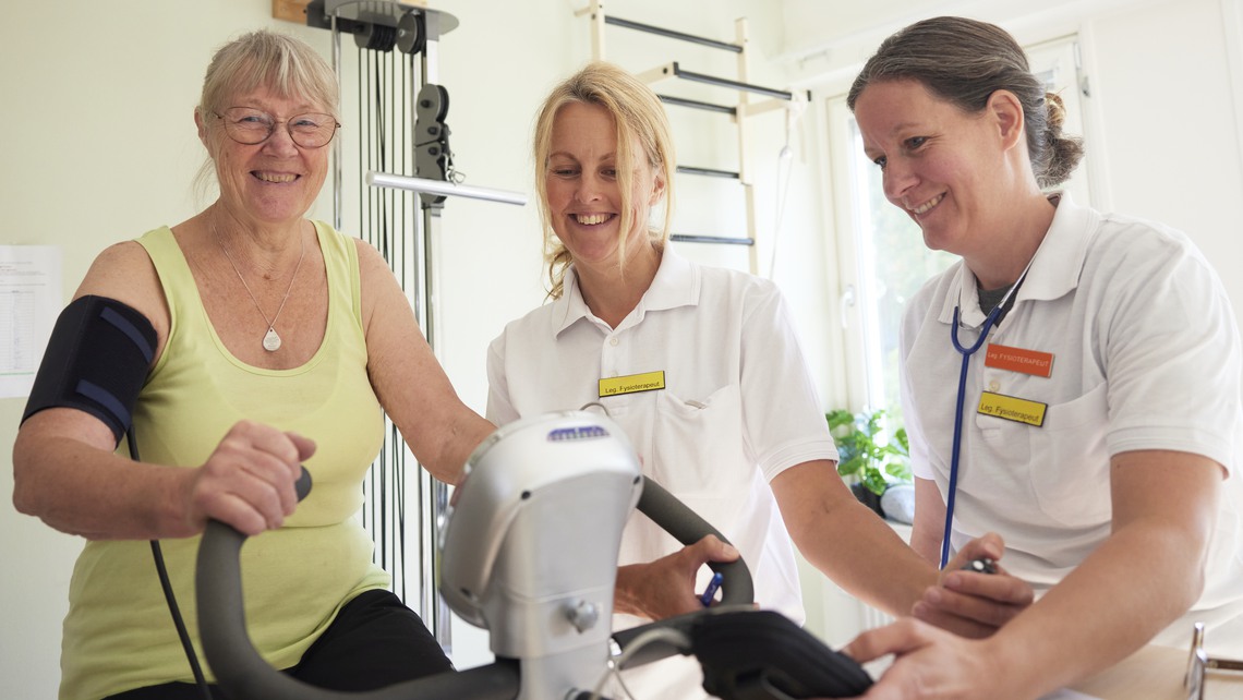Patient på rehabilitering med fysioterapeut på motionscykel