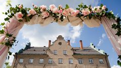 En blomsterbåge utanför Djursholms slott i samband med ett bröllop.