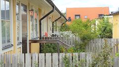 En gul radhuslänga med rött tak i Enebyberg.