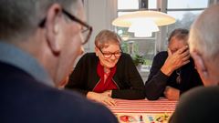 Fyra glada människor spela fia med knuff.
