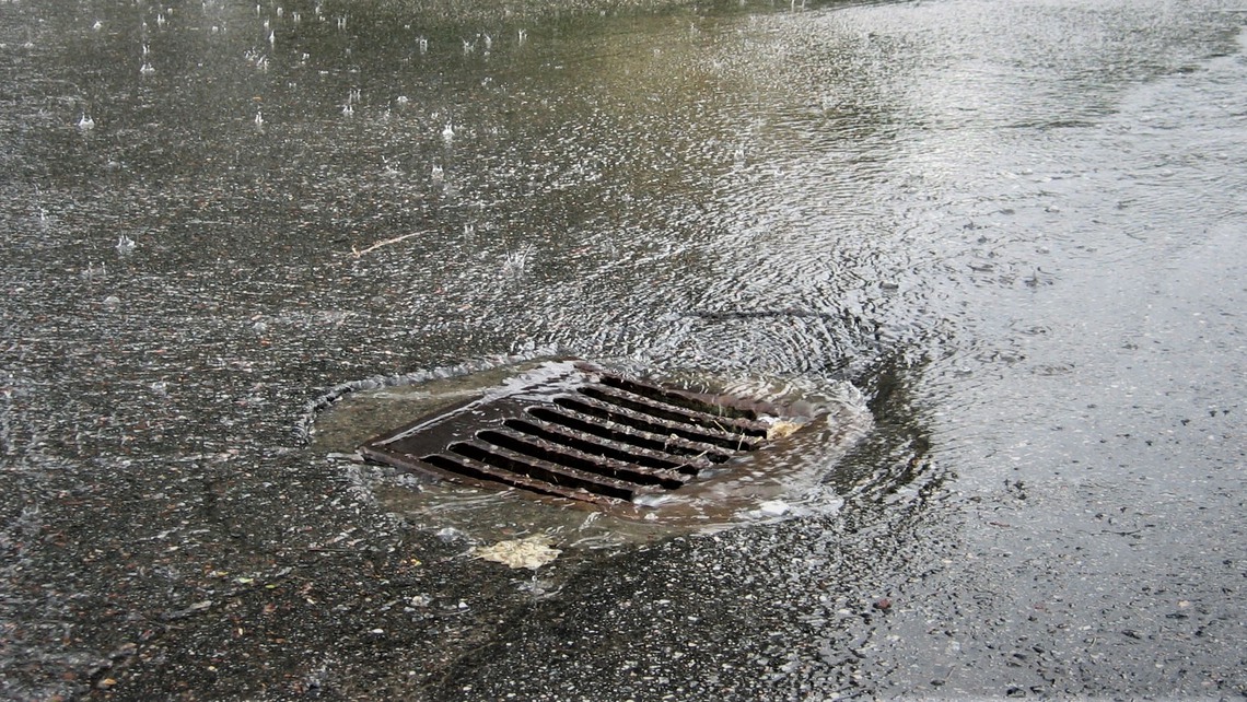 Regnvatten rinner ner i dagvattenbrunn.