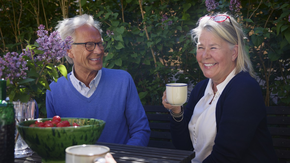 En grupp med människor i olika åldrar fikar utomhus