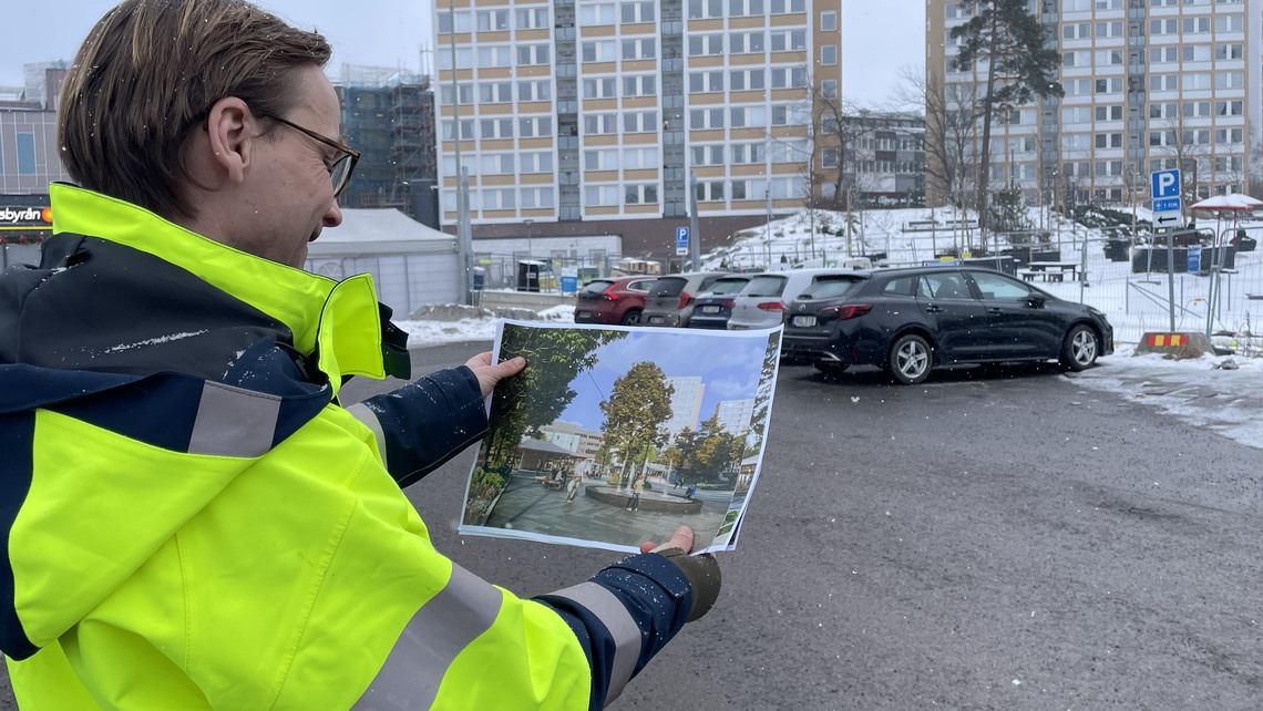 Kommunens projektledare Mats Falås håller upp en visionsbild av hur platsen kommer att se ut om ett par år.