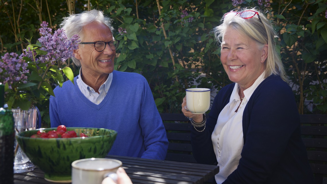 En grupp med människor i olika åldrar fikar utomhus