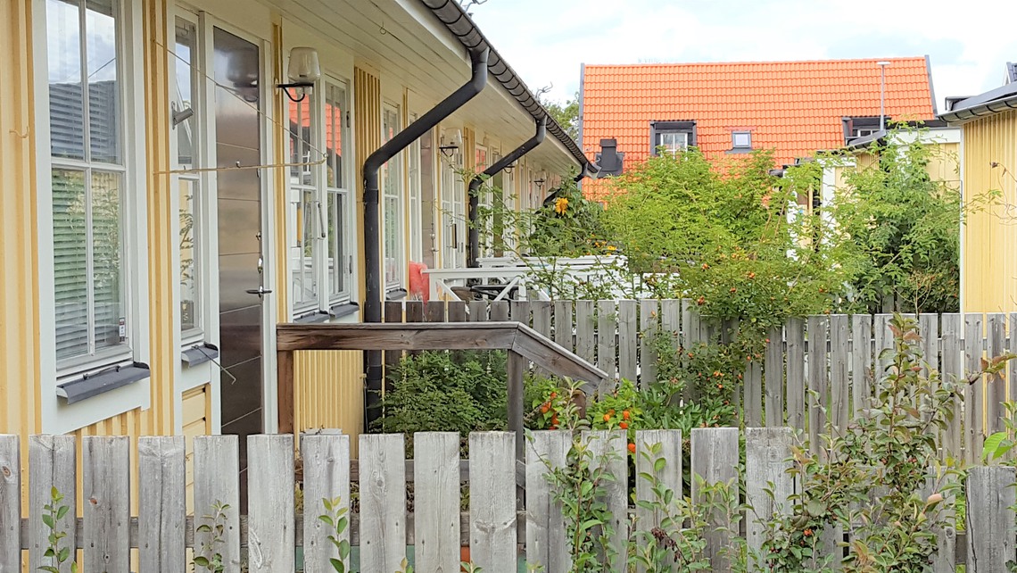 En gul radhuslänga med rött tak i Enebyberg. 