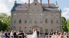 Brudpar på slottsgården med gäster.