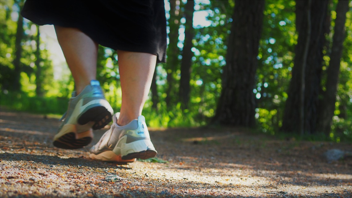 Närbild på gympaskor på stig
