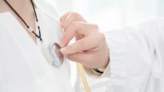 En sköterska undersöker en patient och lyssnar på hennes hjärta.