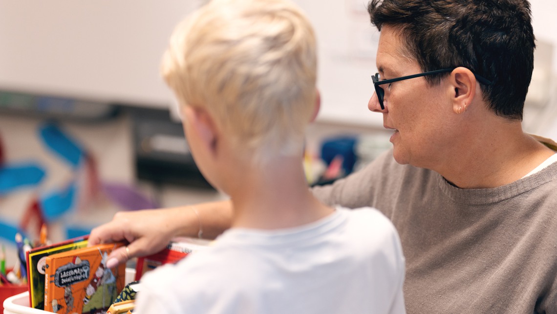 En lärare hjälper en elev under en lektion.