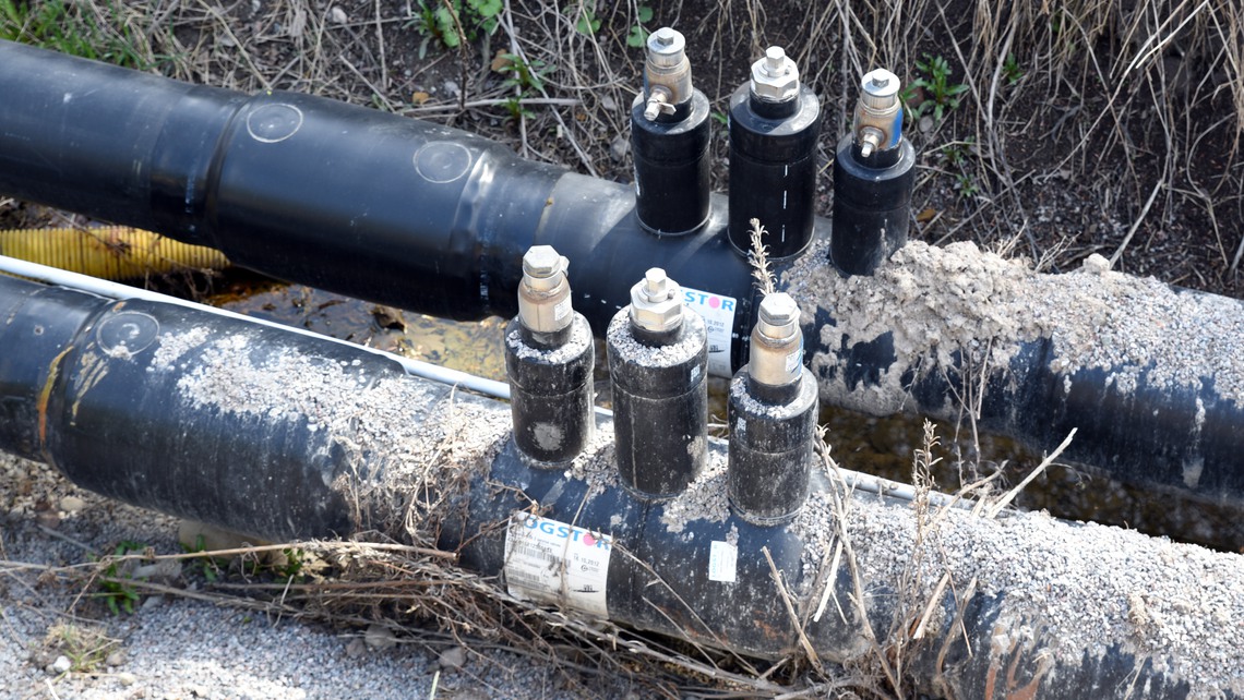 Svarta ledningar i uppgrävt dike.