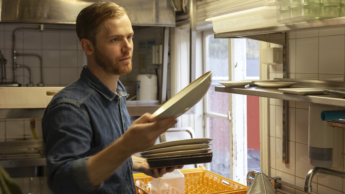 Man sorterar disk i restaurangkök.