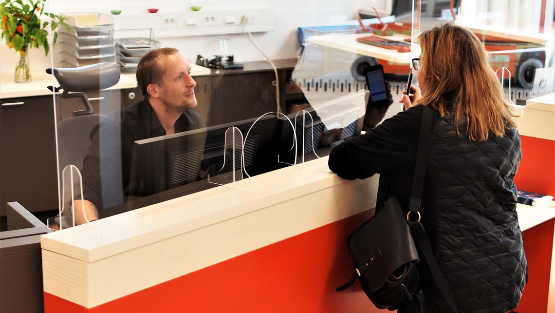 Man hjälper en kund i informationsdisken i kommunens kontaktcenter.