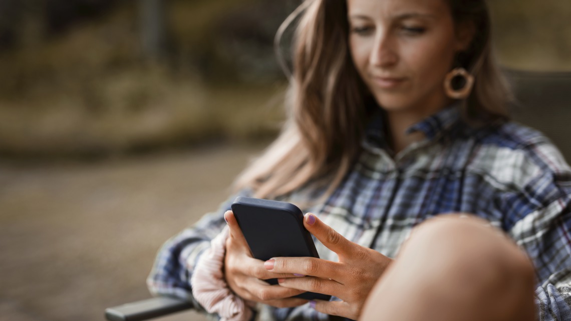 Kvinna med mobil utomhus