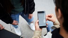 High angle view of man checking map on smart phone while standing with friends