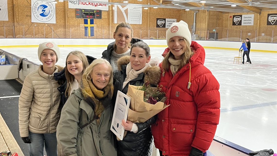 Jennifer Molin står i mitten med blommor och diplom.